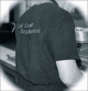 Staff member preparing food at Thai Lotus Restaurant kitchen.