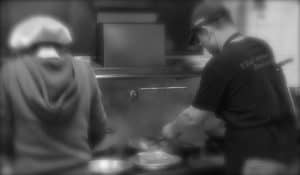 Thai Lotus Restaurant kitchen with chefs preparing traditional Thai dishes.